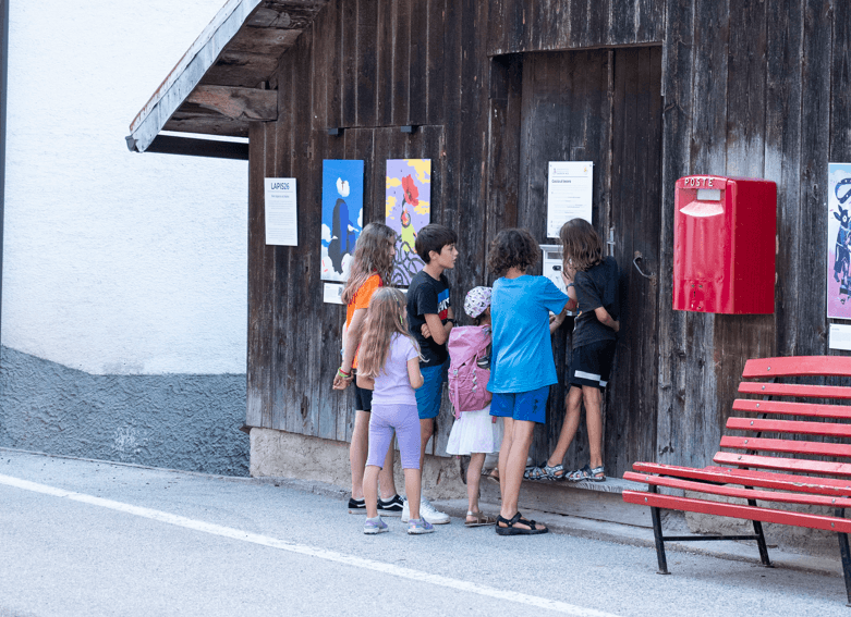 Bambini leggono il pannello della caccia al tesoro a Sagron Mis